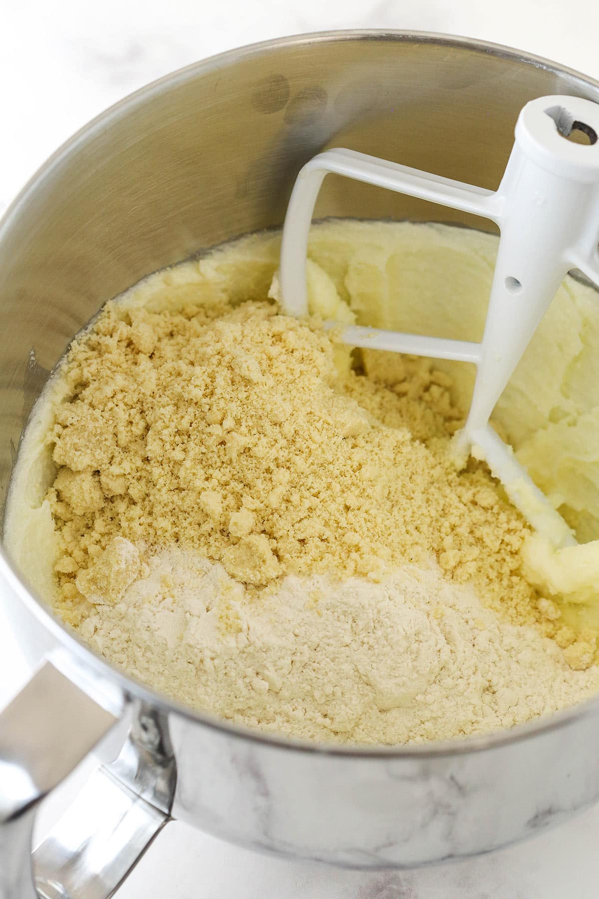 Adding flour to creamed butter and sugar