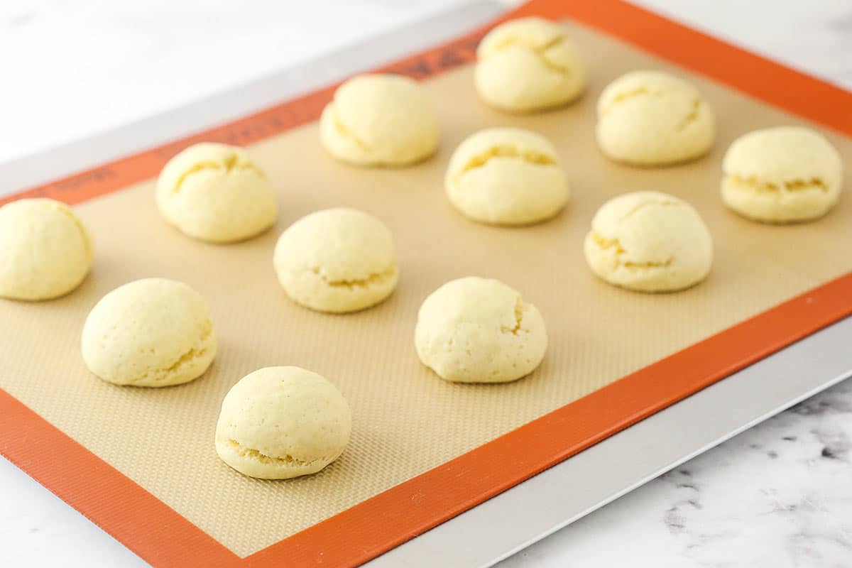 Cooked anise cookies on a silicone baking mat.