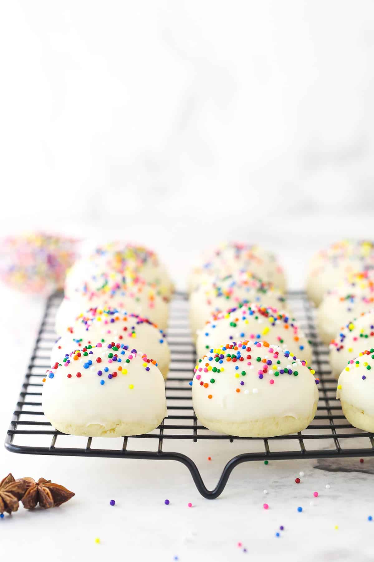 Festive Anise Cookies are soft, flavorful, and not too sweet. These Italian Cookies are a perfect addition to your Christmas gathering. Iced anise cookies on a cooking rack.