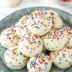 Iced anise cookies staked on a serving plate.