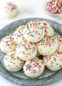 Iced anise cookies staked on a serving plate.