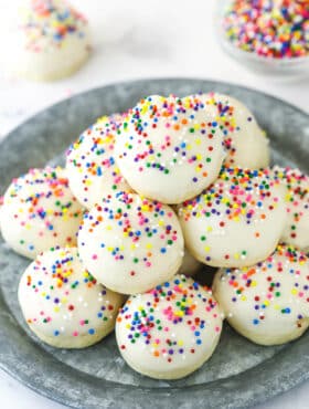 Iced anise cookies staked on a serving plate.