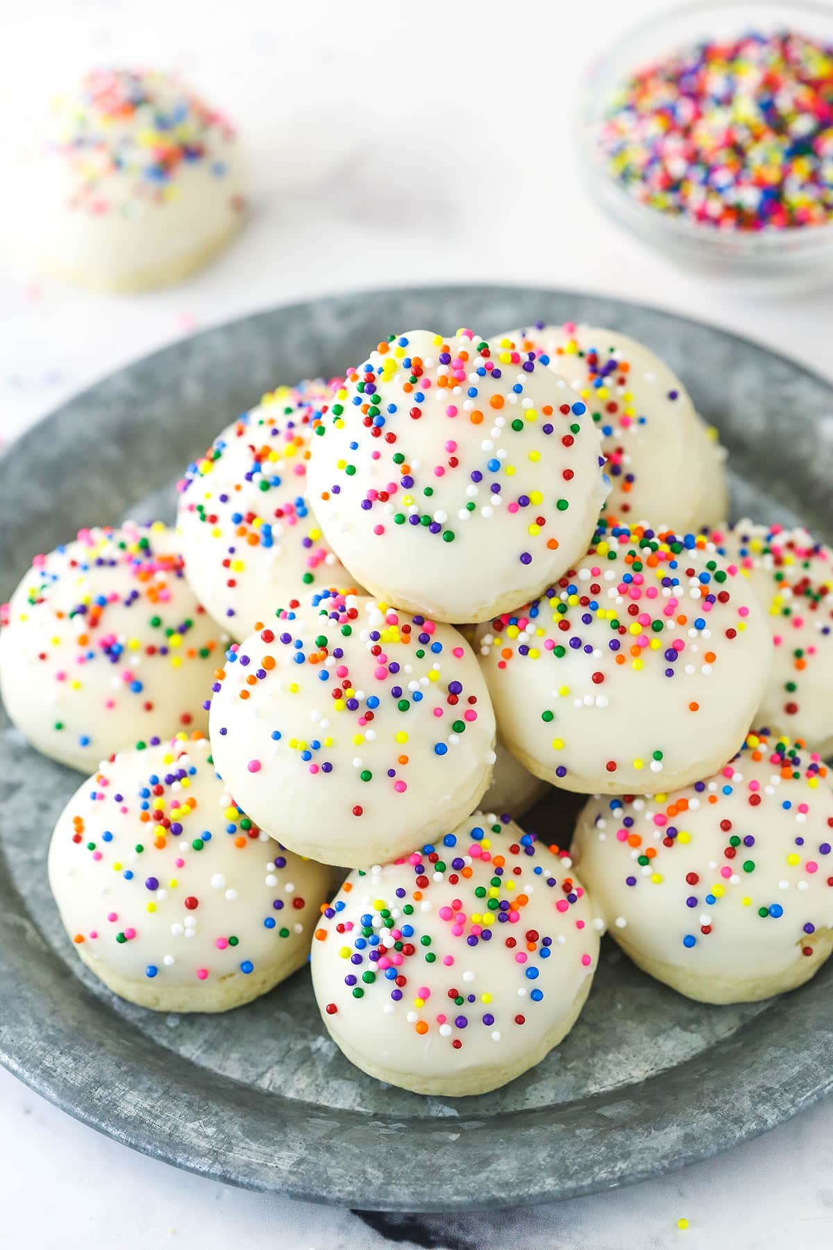 Iced anise cookies staked on a serving plate.