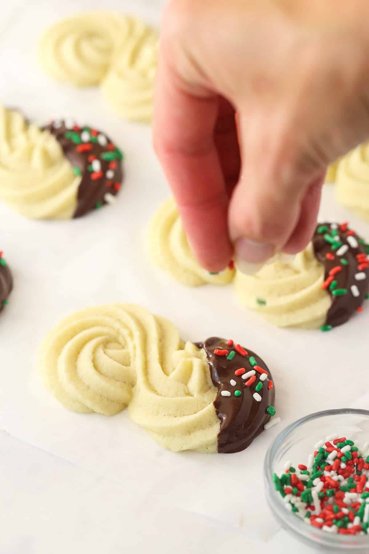 Adding sprinkles to the spritz cookies