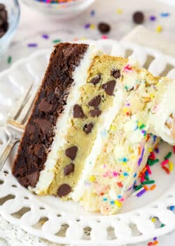 slice of ultimate layered cookie cake on a white plate