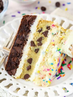 slice of ultimate layered cookie cake on a white plate