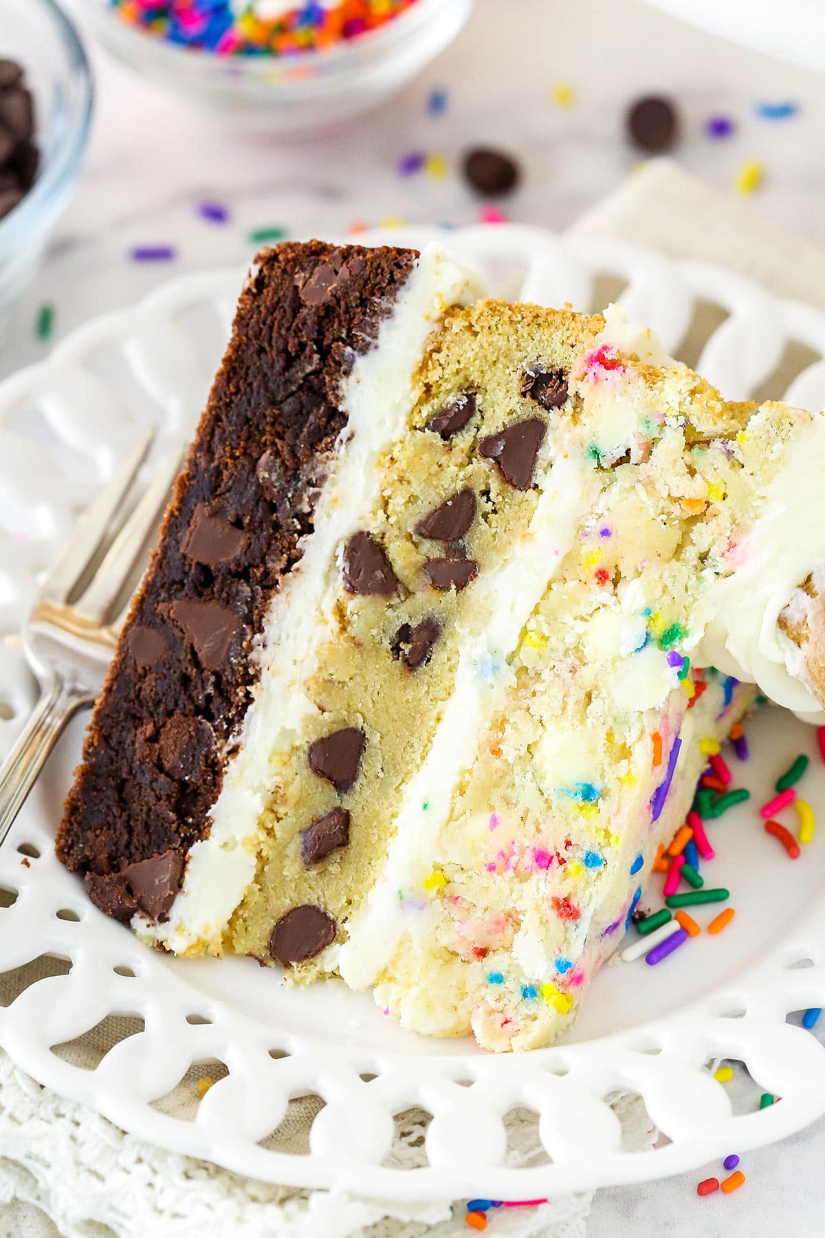 slice of ultimate layered cookie cake on a white plate