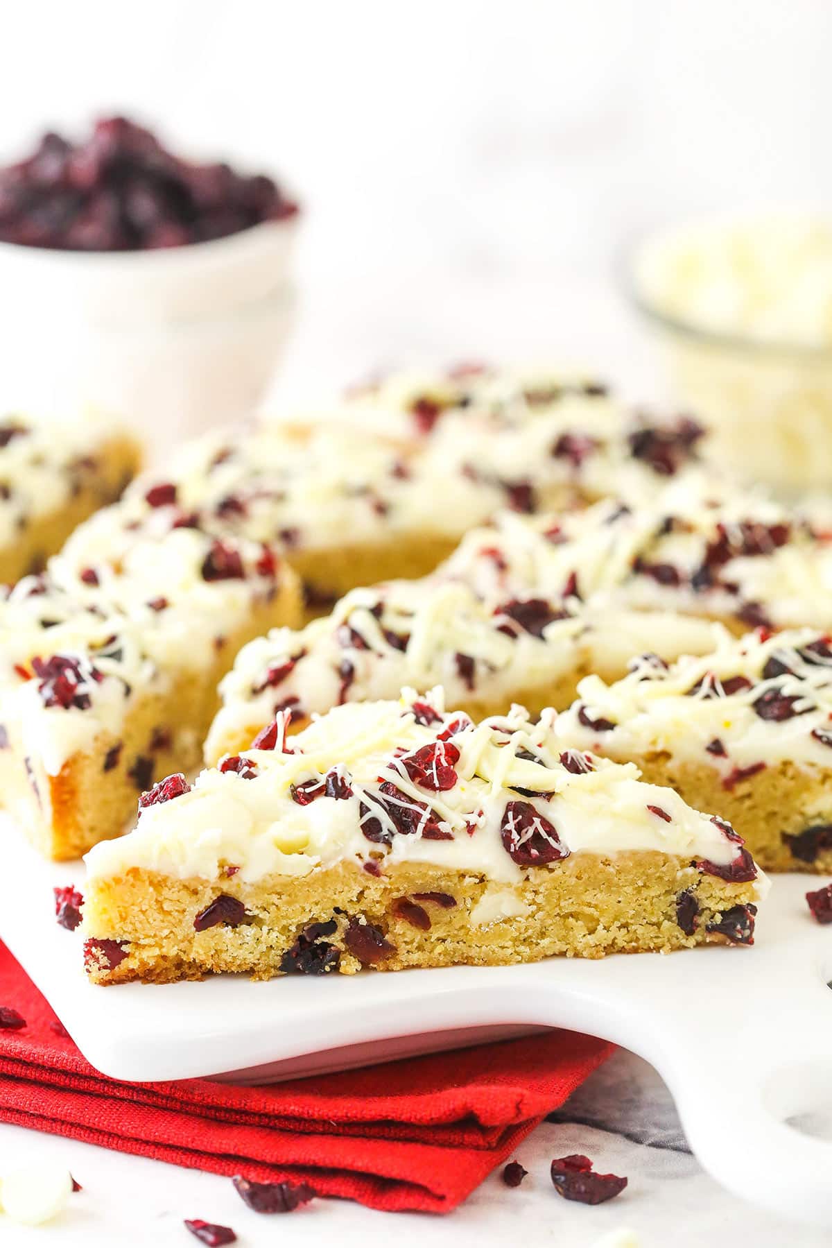 Cut up cranberry bliss bars on a white plate