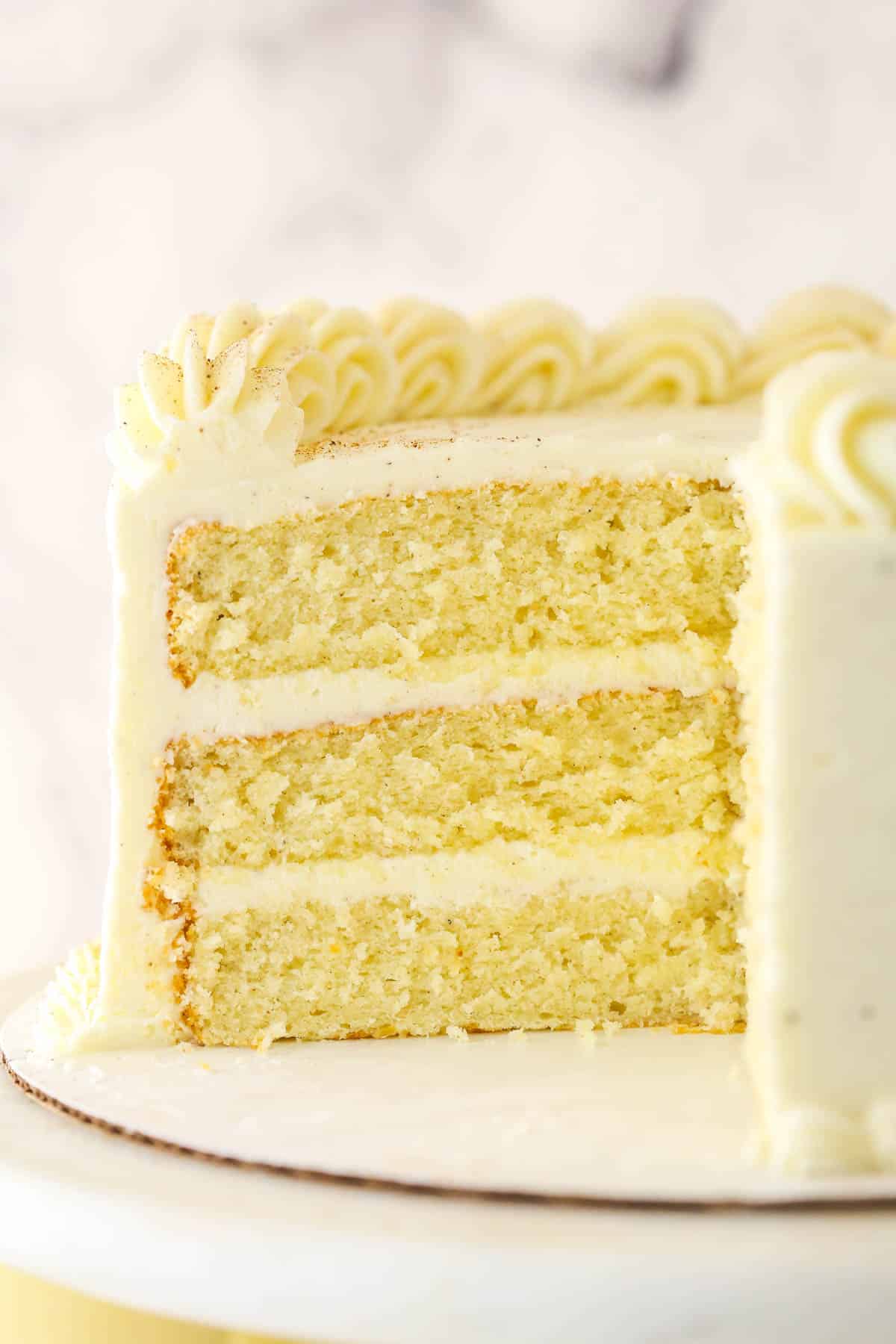 This Eggnog Cake is super moist, fluffy, and FULL of eggnog flavor. This impressive Christmas cake is perfect for your holiday celebration! Eggnog cake with a big slice taken out