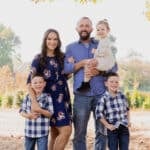 all 5 family members standing together under a tree