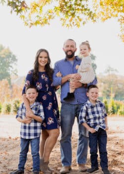 all 5 family members standing together under a tree