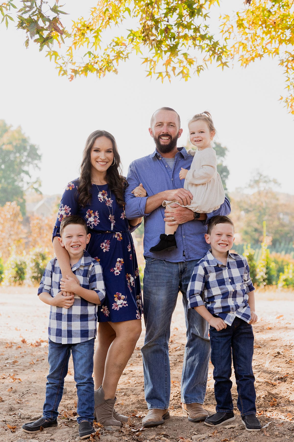 all 5 family members standing together under a tree