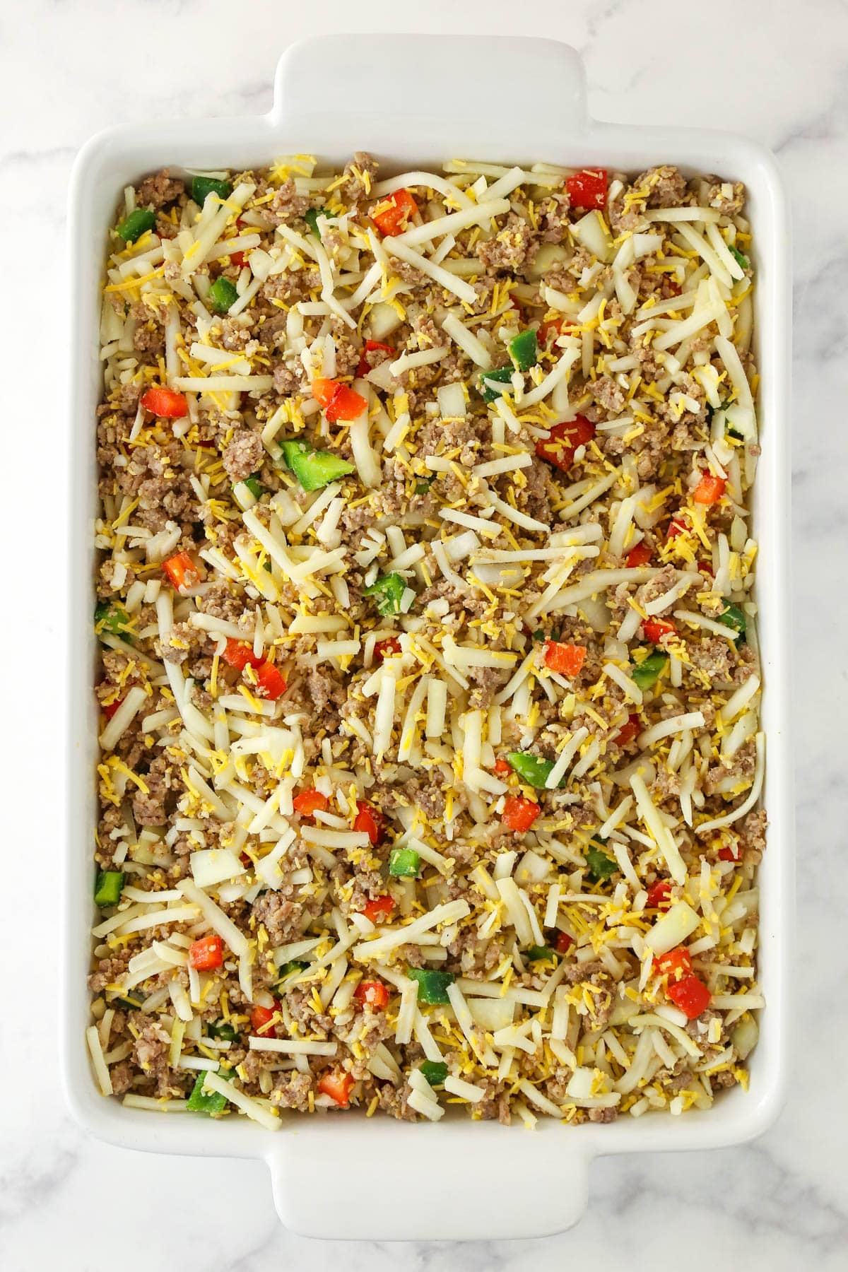 This Hashbrown Breakfast Casserole is perfect when you need to feed a crowd in the morning. Perfect for Christmas, Thanksgiving, or brunch! Hashbrown Breakfast Casserole ready to go in the oven