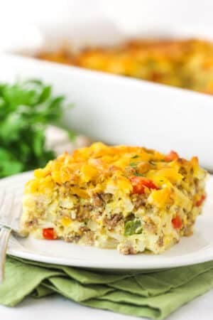 A piece of hashbrown breakfast casserole on a plate ready to be eaten