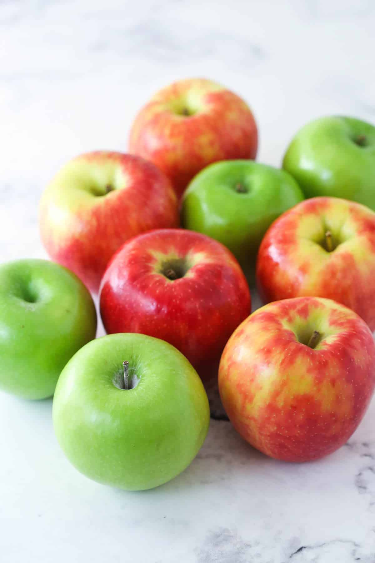 A mix of red and green apples on the counter.