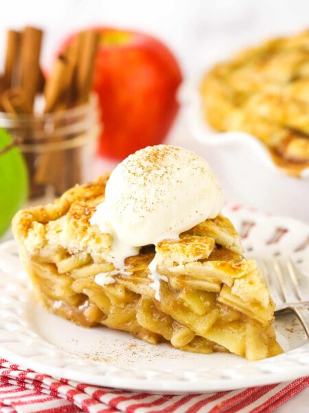 A slice of apple pie with vanilla ice cream on top.