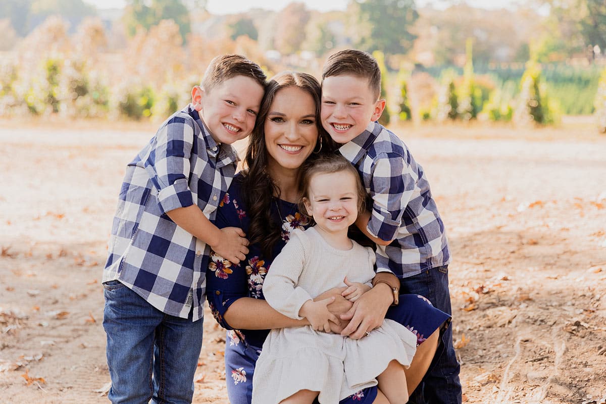 Lindsay kneeling down with the 3 kids around her