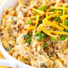 Million dollar dip in a bowl next to Ritz crackers.