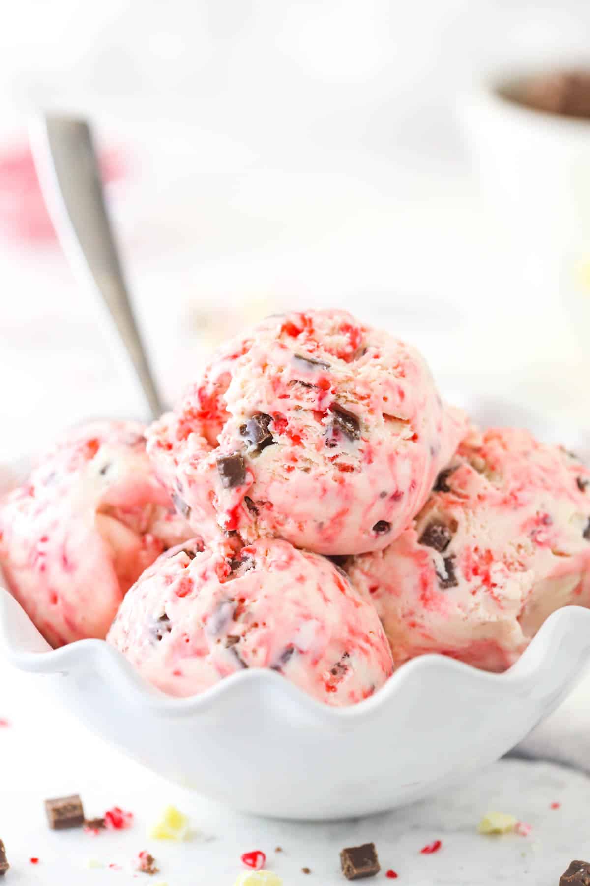 A white bowl filled with scoops of peppermint bark ice cream