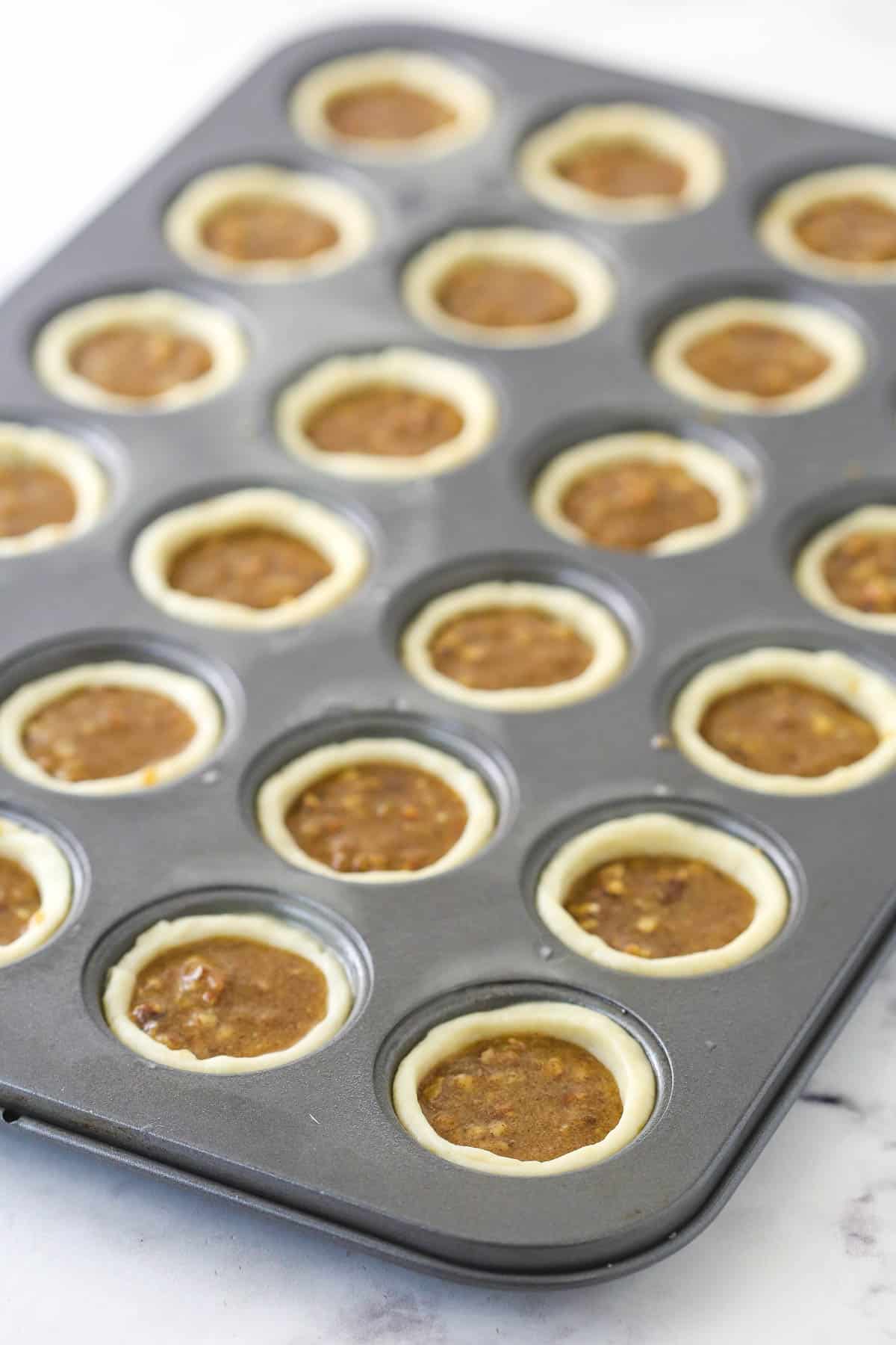 Adding the pecan filling to the muffin cups