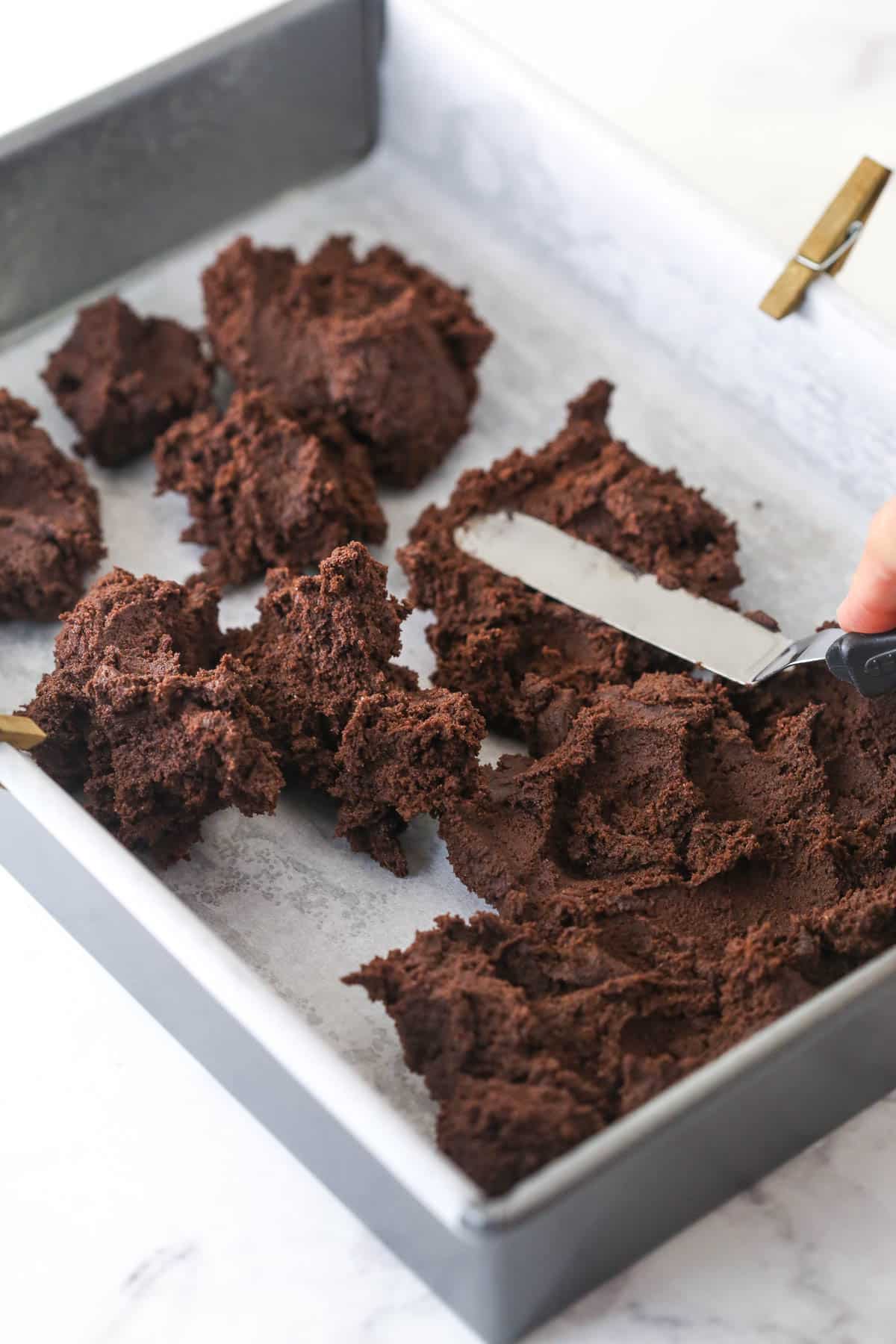 Putting spoonfuls of cookie batter into the prepared baking pan