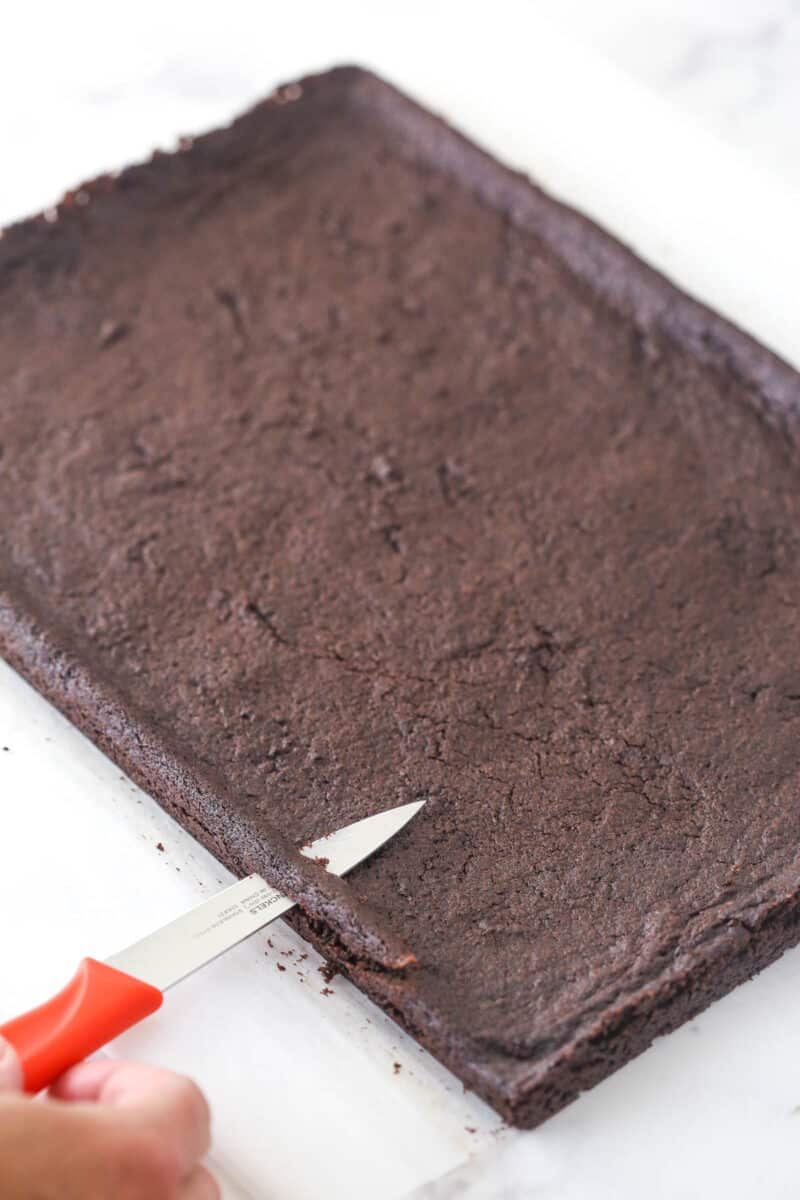 Trimming the raised sides off the cookie layer.