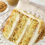 slice of toffee layer cake on white plate with toffee sauce in the background