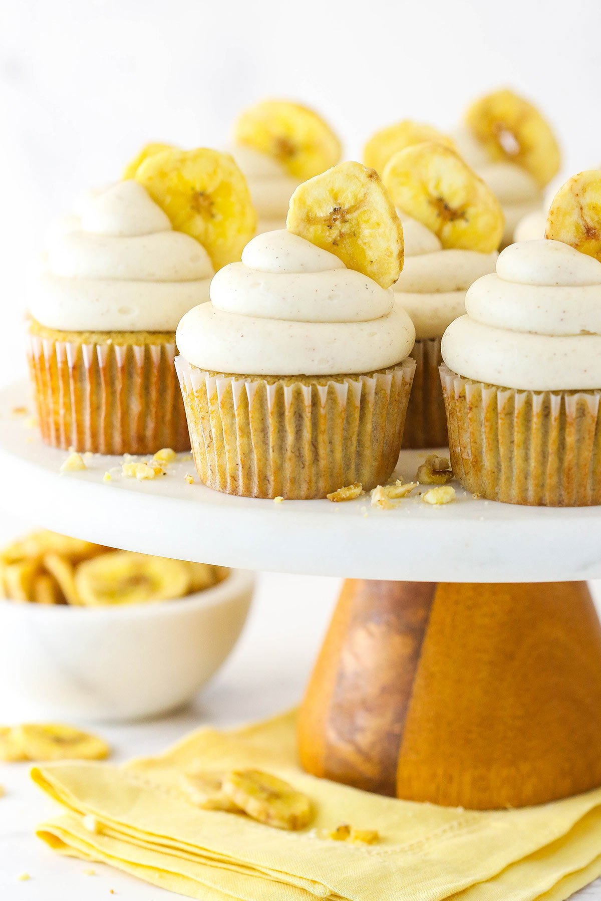 Banana cupcakes with cinnamon cream cheese frosting and a banana chip.