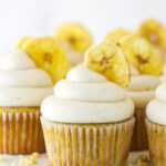 Banana cupcakes with cinnamon cream cheese frosting and a banana chip.