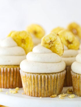 Banana cupcakes with cinnamon cream cheese frosting and a banana chip.