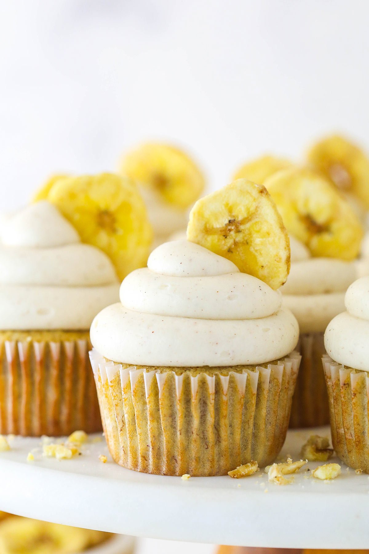 Banana cupcakes with cinnamon cream cheese frosting and a banana chip.