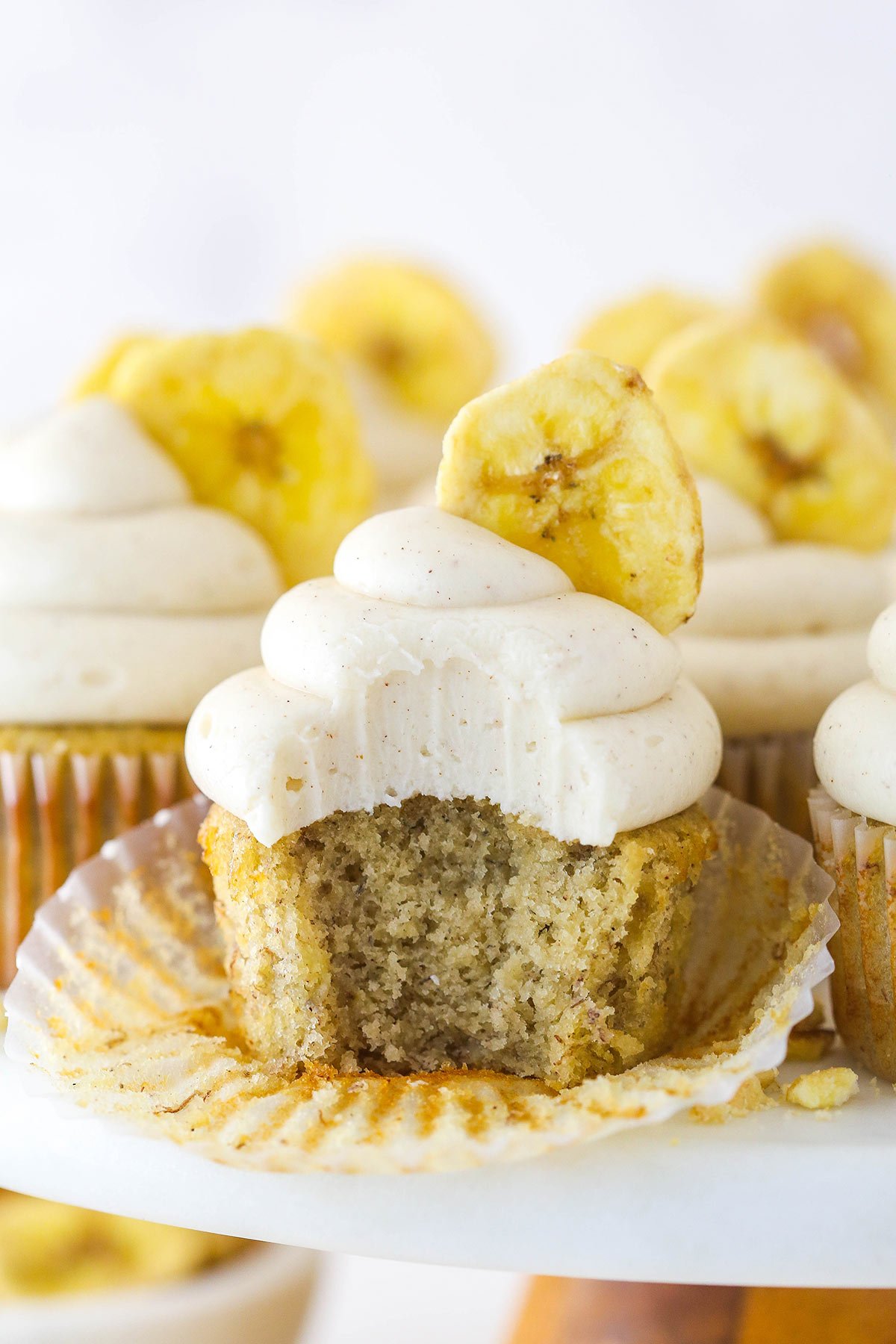 Bitten into banana cupcake with a banana chip.