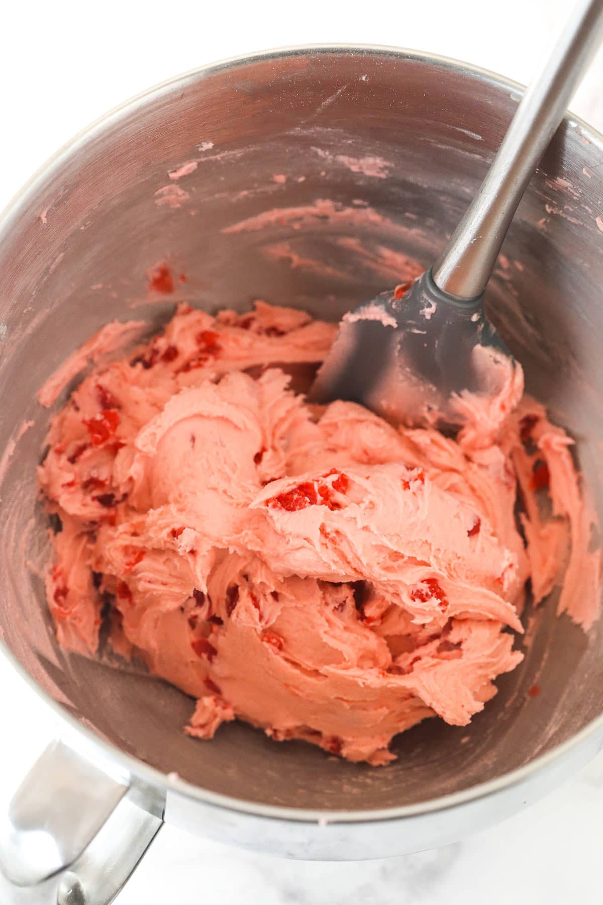 Dough with chopped cherries in a bowl. 