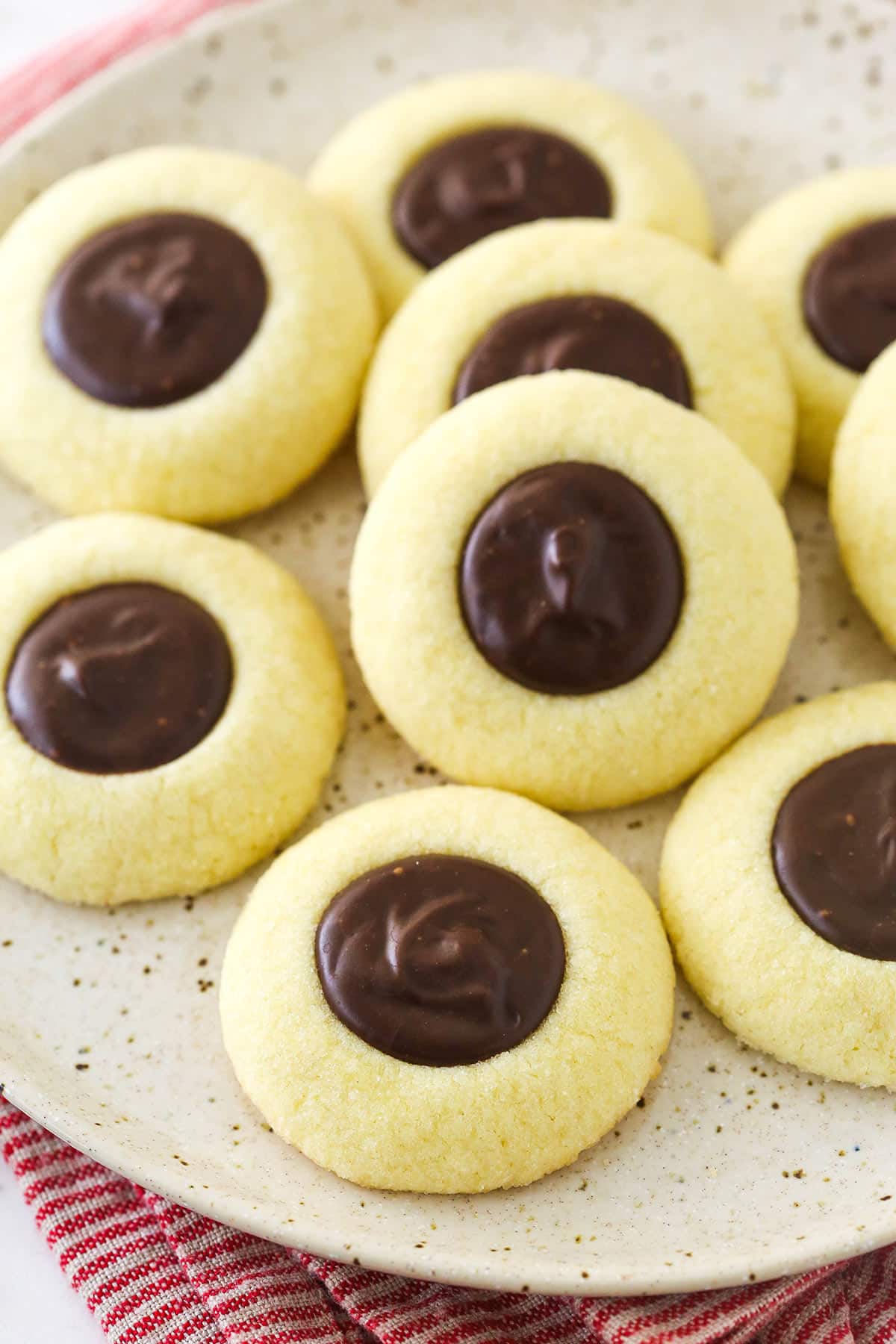 chocolate thumbprint cookies on speckled plate and red striped napkin