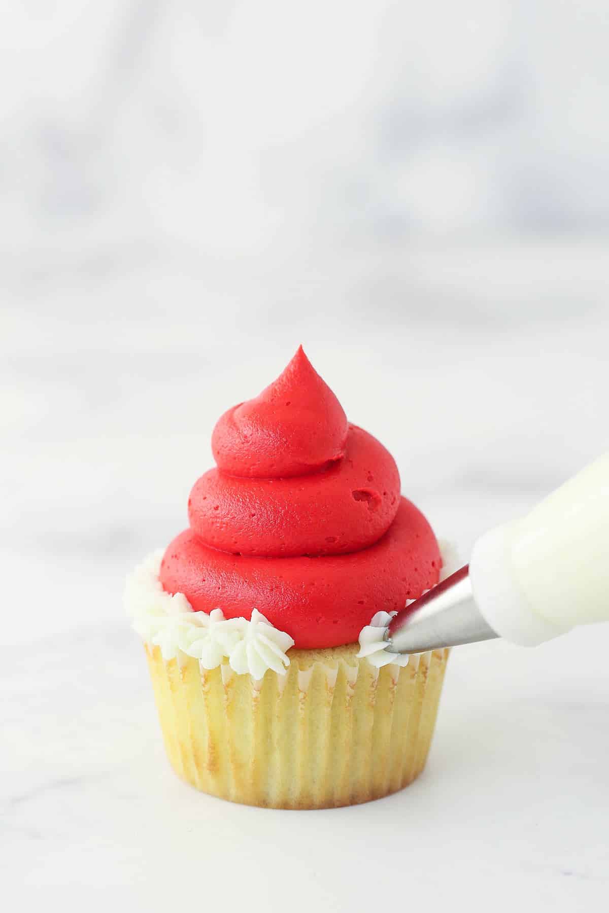 piping the bottom white part of the santa hat onto the cupcake