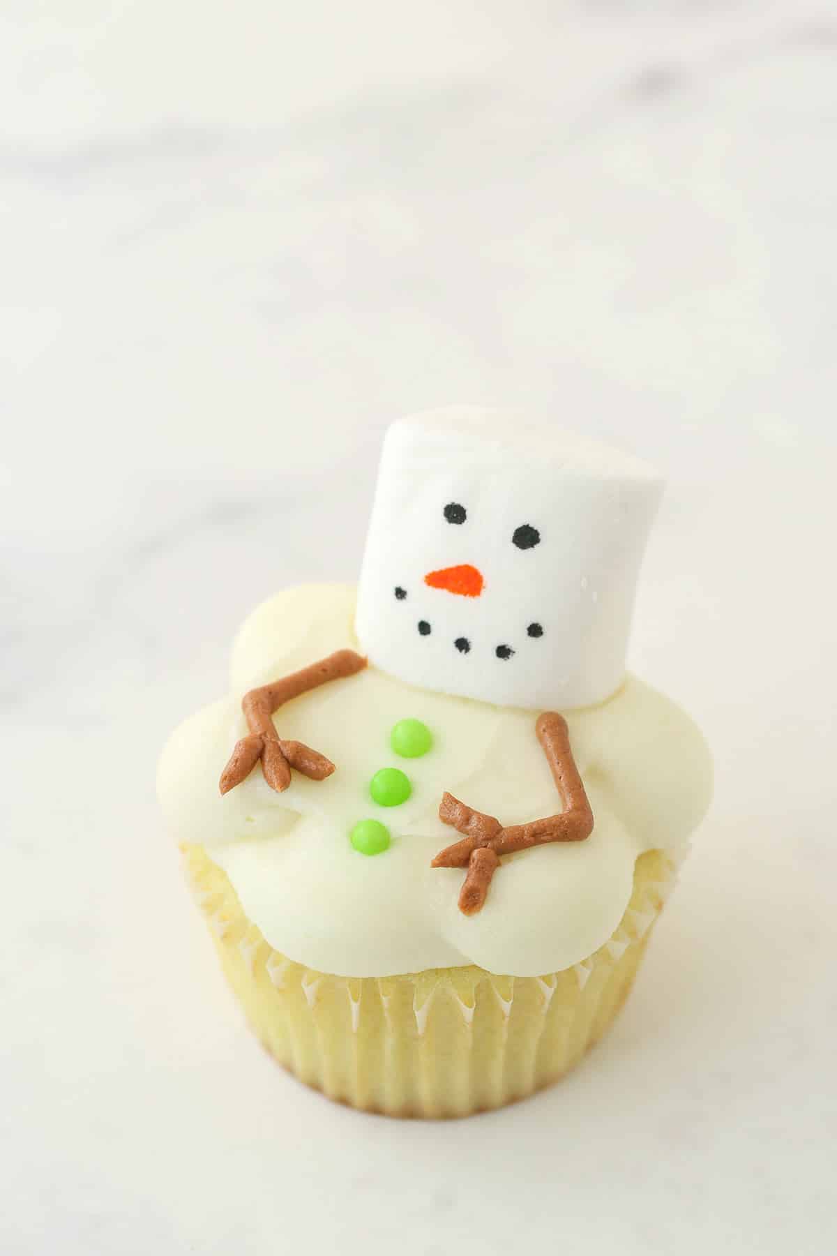 finished melting snowman cupcake on marble background