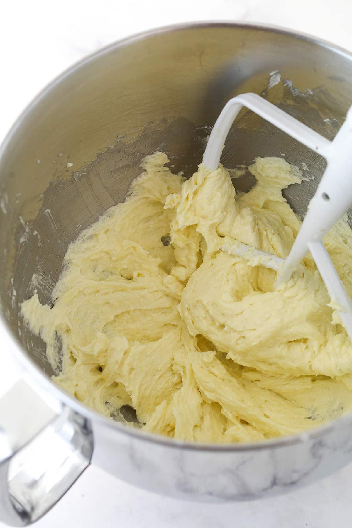 Adding the extracts and egg to the creamed butter.