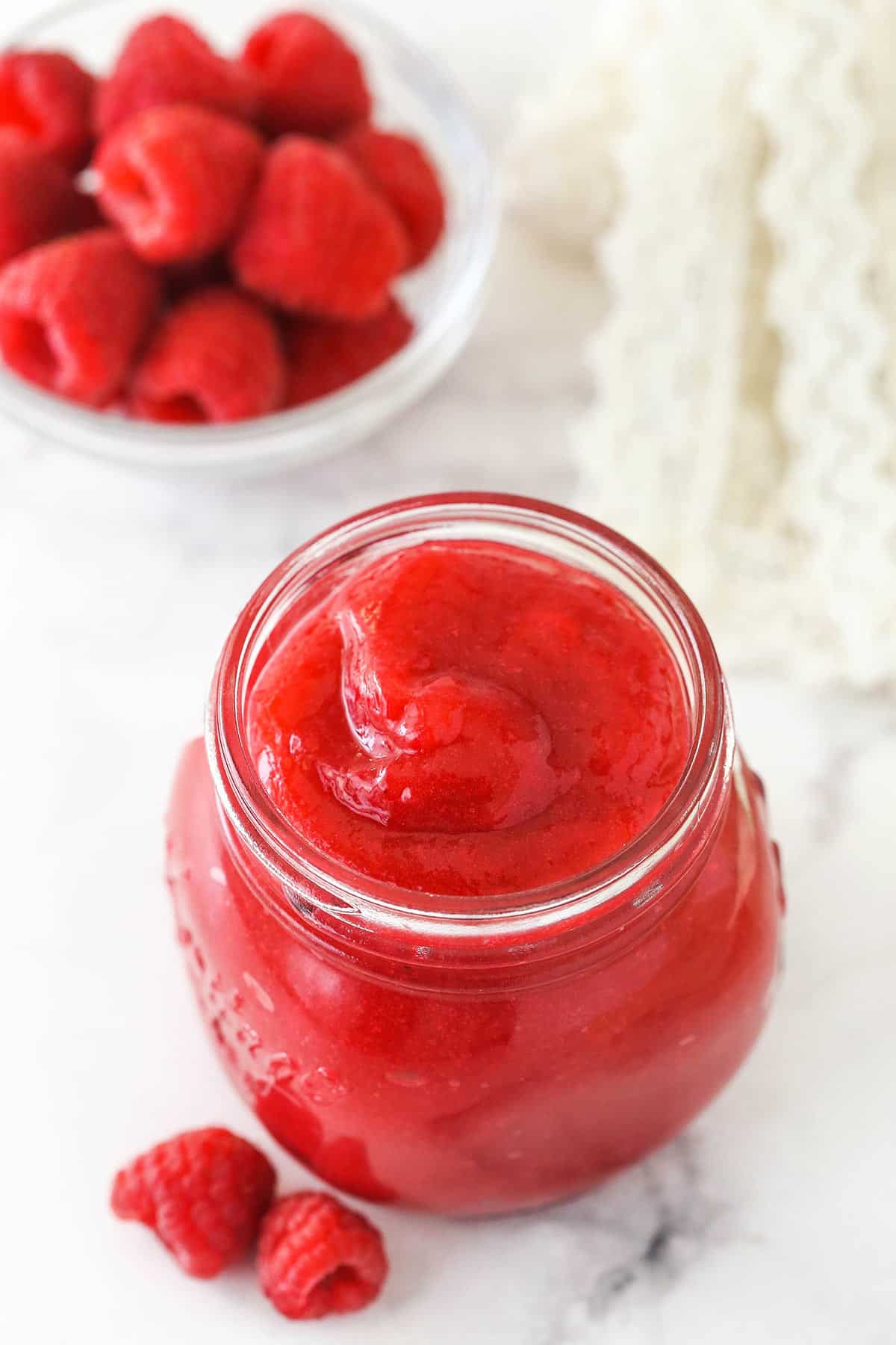 Raspberry filling for cake in a glass jar.