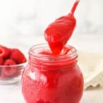 Raspberry filling for cake in a glass jar.