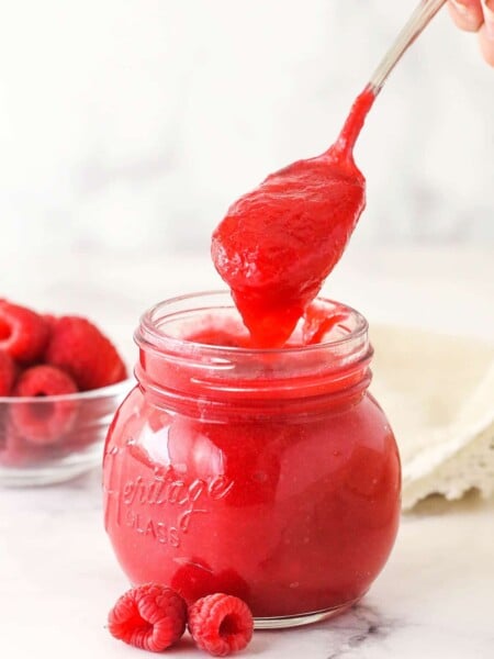 Raspberry filling for cake in a glass jar.