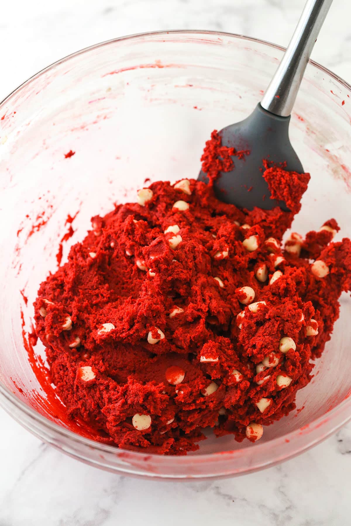 These sweet and creamy red velvet cookies with white chocolate chips are an irresistible treat for your cookie boxes this holiday season. Folding in the white chocolate chips.