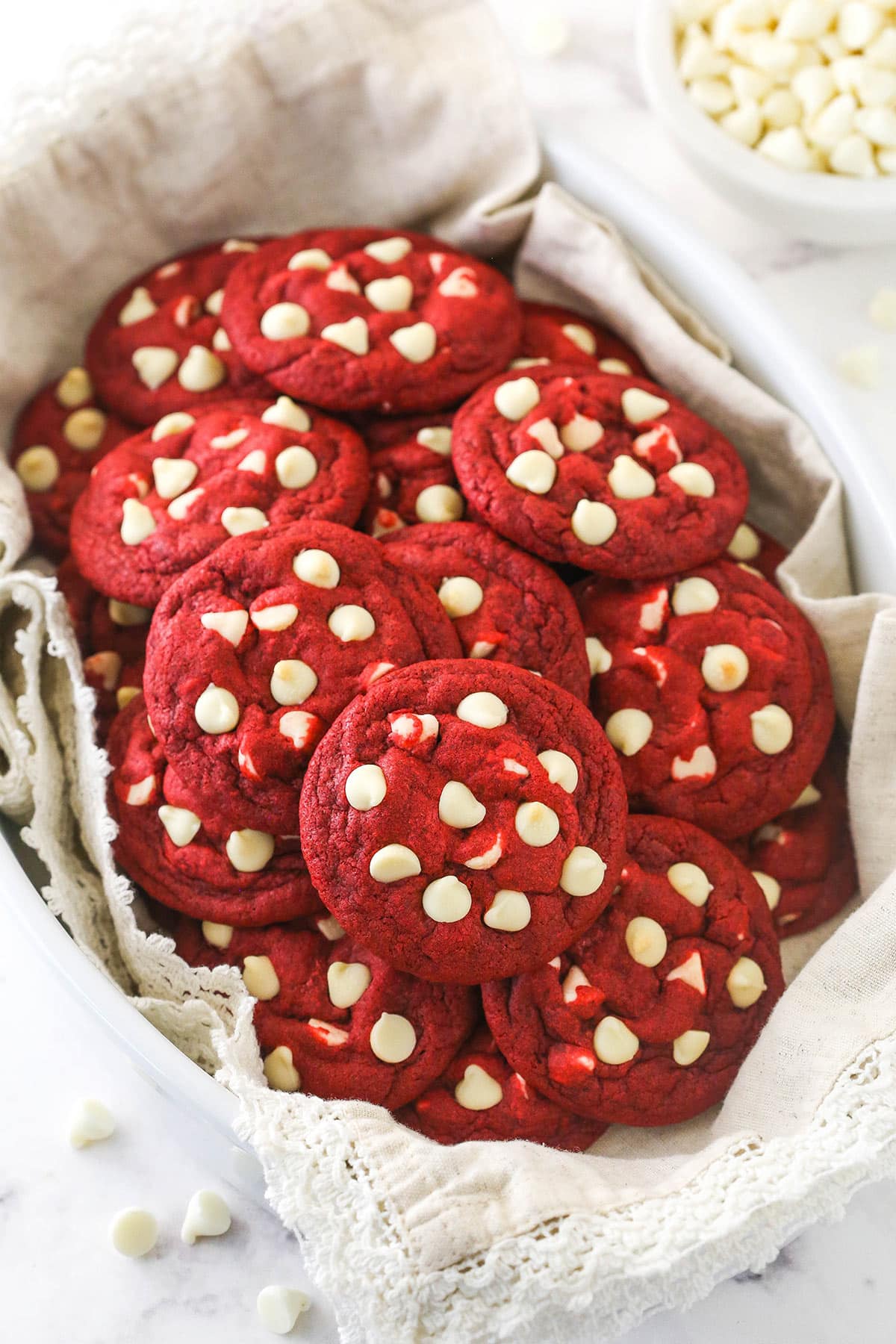 Red velvet cookies with white chocolate chips in a container.