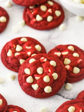 Angled shot of three red velvet cookies with white chocolate chips.