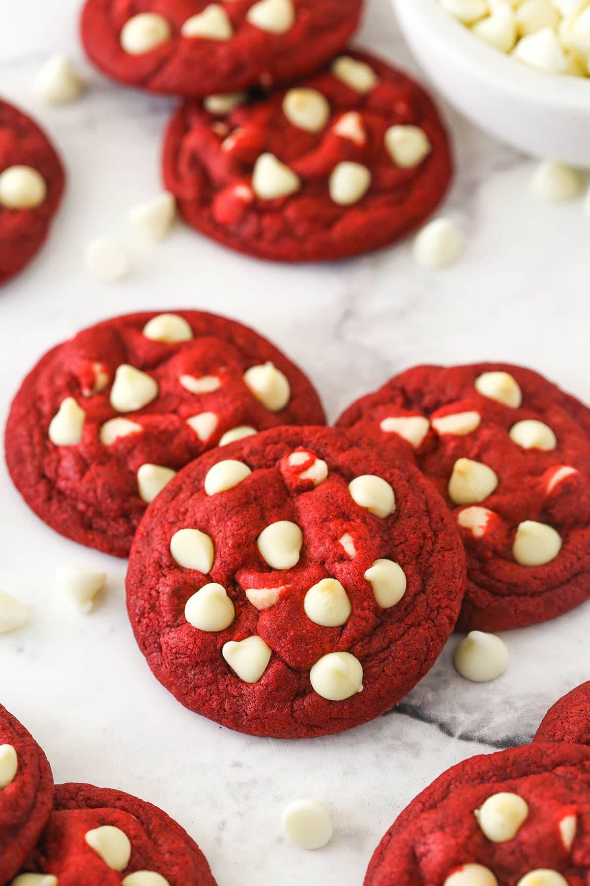 Angled shot of three red velvet cookies with white chocolate chips.