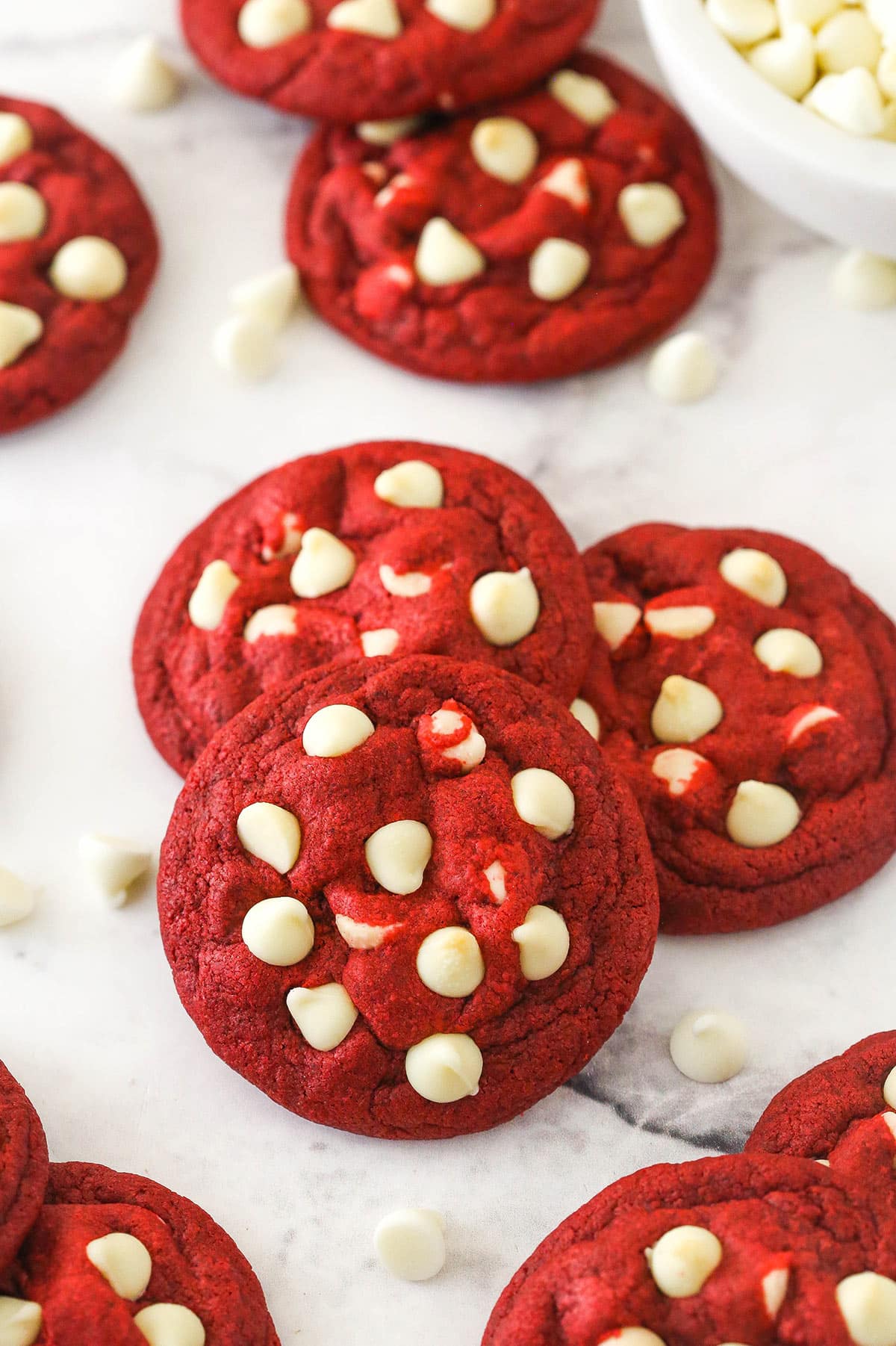 These sweet and creamy red velvet cookies with white chocolate chips are an irresistible treat for your cookie boxes this holiday season. Small stack of red velvet cookies with white chocolate chips.