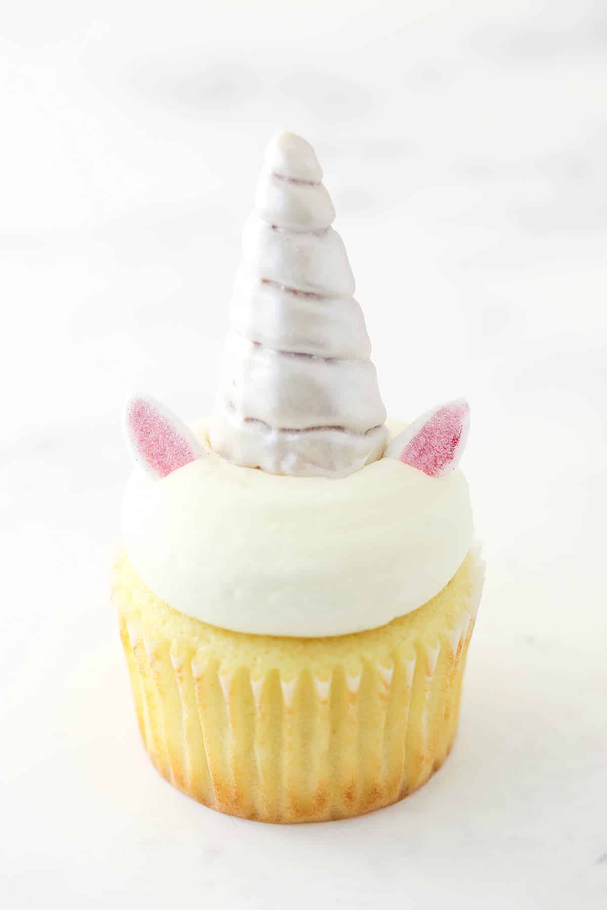 Vanilla cupcake with buttercream, a horn, and two ears.