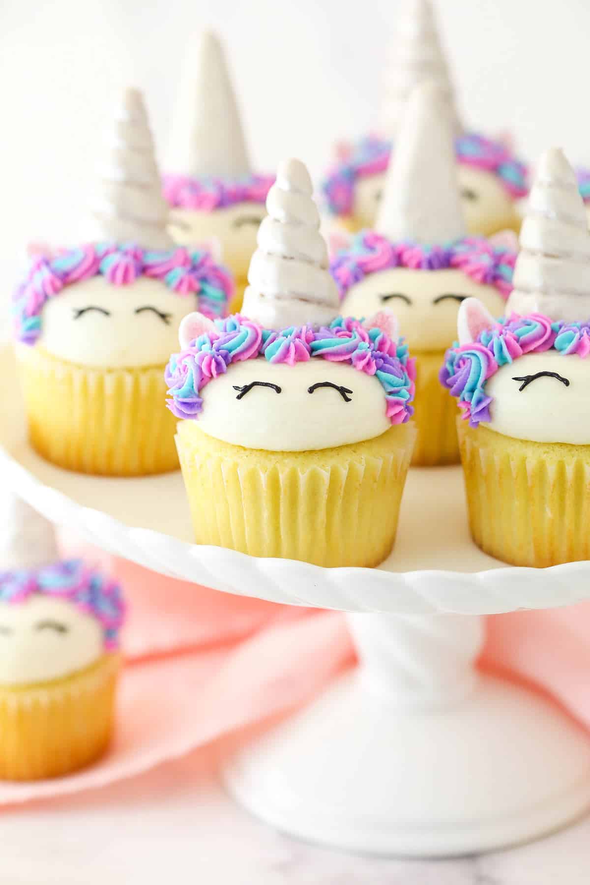 Easy unicorn cupcakes on a white cake stand.