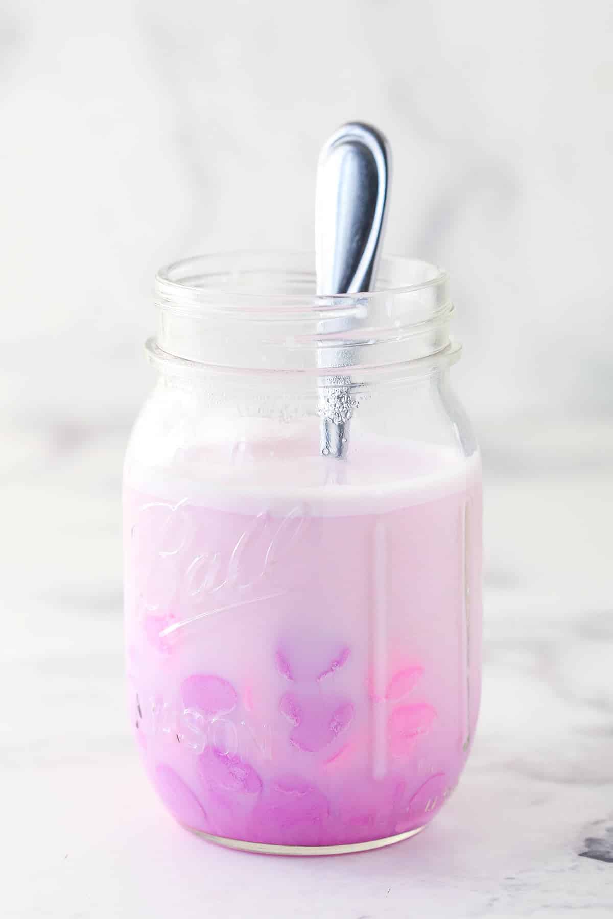 Infusing conversation heart candies into warm milk for conversation heart cupcakes.