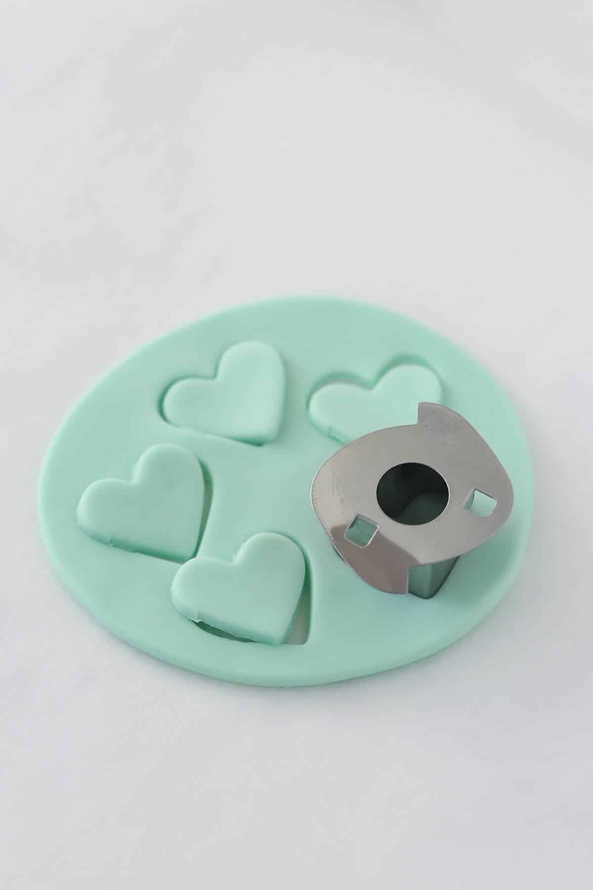 Cutting fondant hearts for conversation heart cupcakes.