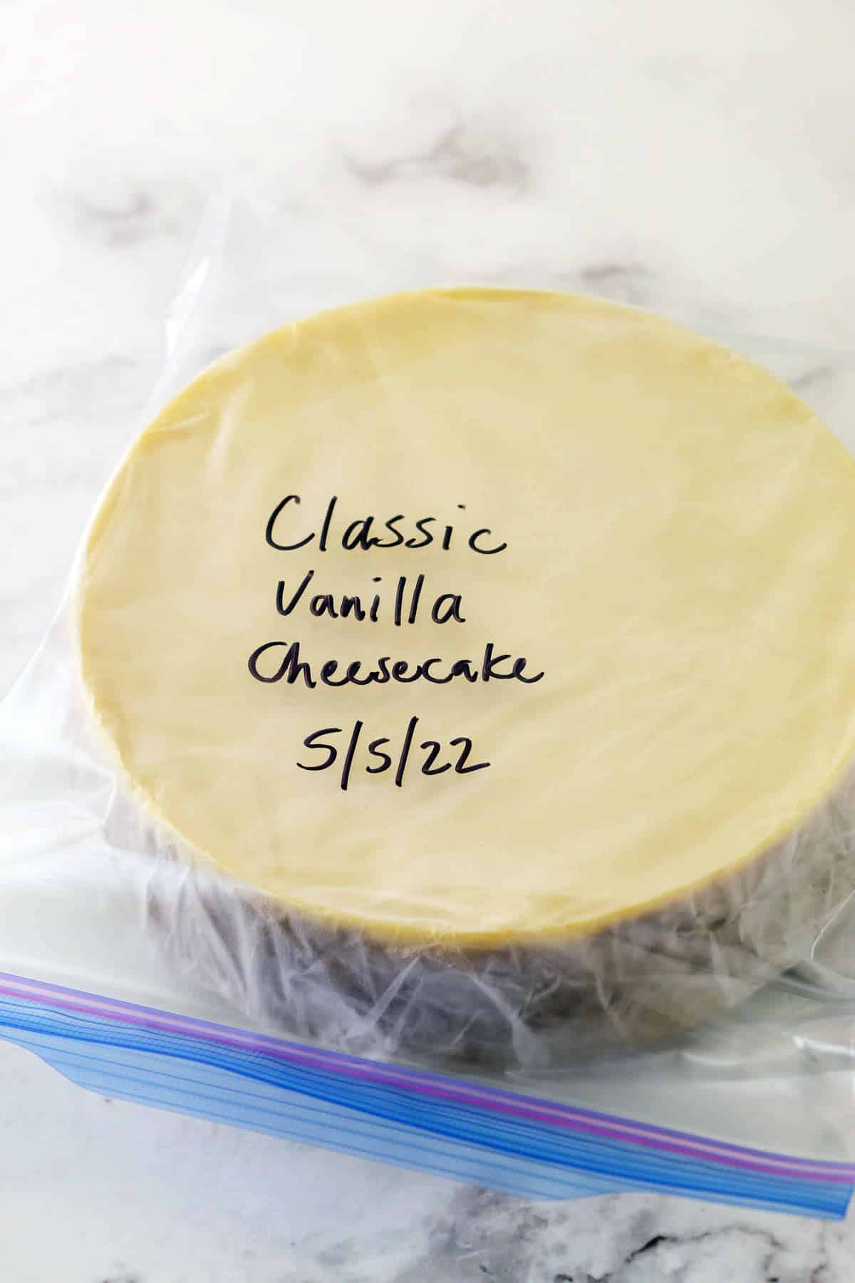 a whole cheesecake wrapped in plastic wrap and in a ziplock bag with the name and date on it
